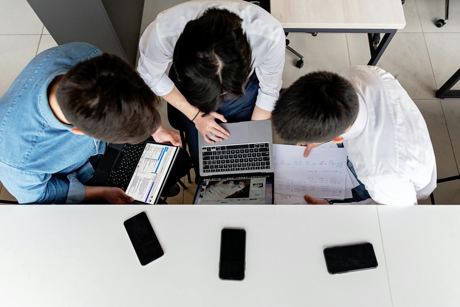 Team collaborating around laptops